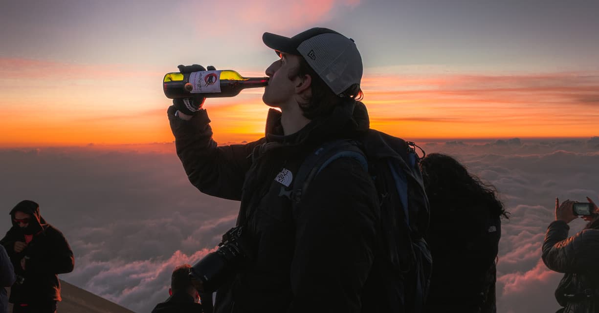 Sunrise toast above the clouds at the summit of a volcano